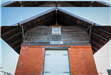 An image of the old red brick and rustic wood Rosser train depot. 