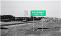 A black and white image of the green and white Kaufman County Line sign on east US 175.. 