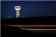 An image of teh Terrell water tower all lit up at night on US 80.
