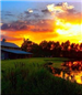 A beautiful sunset behind a farmhouse in a Kaufman County field.