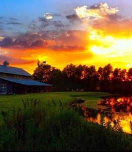 A beautiful sunset behind a farmhouse in a Kaufman County field.